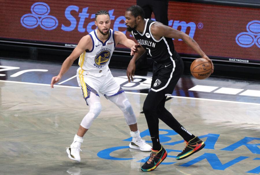 NEW YORK, NEW YORK - DECEMBER 22: Kevin Durant #7 of the Brooklyn Nets dribbles against Stephen Curry #30 of the Golden State Warriors during the first half at Barclays Center on December 22, 2020 in the Brooklyn borough of New York City. NOTE TO USER: User expressly acknowledges and agrees that, by downloading and/or using this photograph, user is consenting to the terms and conditions of the Getty Images License Agreement. (Photo by Sarah Stier/Getty Images)