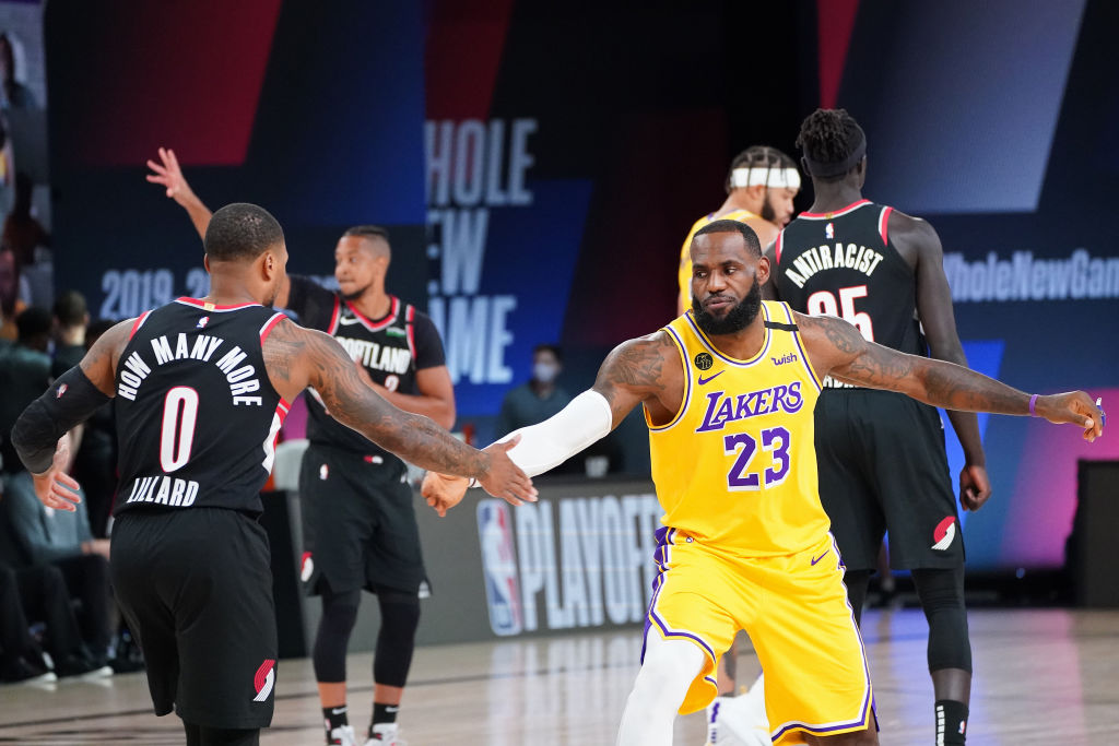 ORLANDO, FL - AUGUST 18: Damian Lillard #0 of the Portland Trail Blazers and LeBron James #23 of the Los Angeles Lakers high five during Round One, Game One of the NBA Playoffs on August 18, 2020 at the AdventHealth Arena at ESPN Wide World Of Sports Complex in Orlando, Florida. NOTE TO USER: User expressly acknowledges and agrees that, by downloading and/or using this Photograph, user is consenting to the terms and conditions of the Getty Images License Agreement. Mandatory Copyright Notice: Copyright 2020 NBAE (Photo by Jesse D. Garrabrant/NBAE via Getty Images)