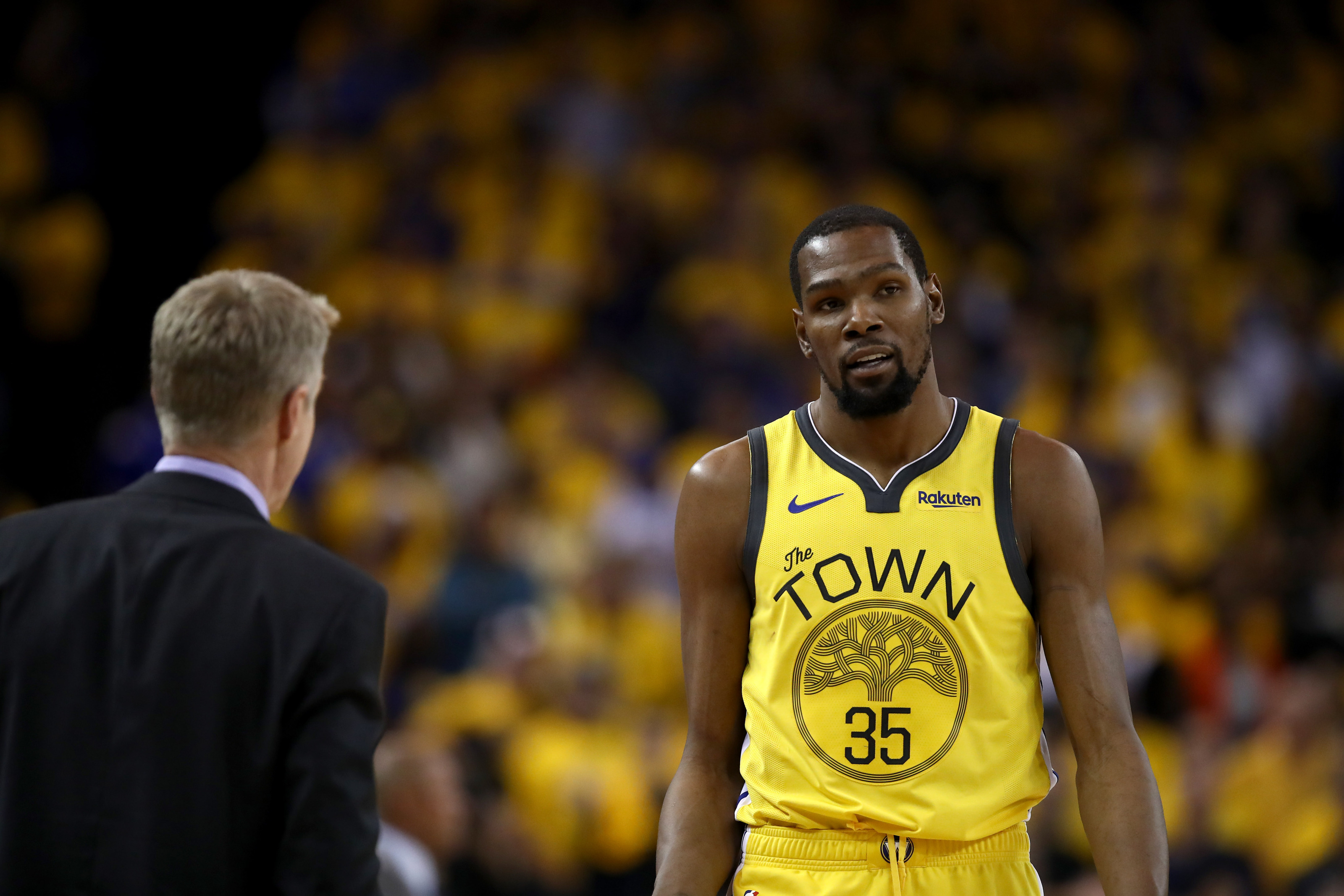 OAKLAND, CALIFORNIA - APRIL 15: Kevin Durant #35 of the Golden State Warriors talks to head coach Steve Kerr during Game Two of the first round of the 2019 NBA Western Conference Playoffs at ORACLE Arena on April 15, 2019 in Oakland, California. NOTE TO USER: User expressly acknowledges and agrees that, by downloading and or using this photograph, User is consenting to the terms and conditions of the Getty Images License Agreement. (Photo by Ezra Shaw/Getty Images)