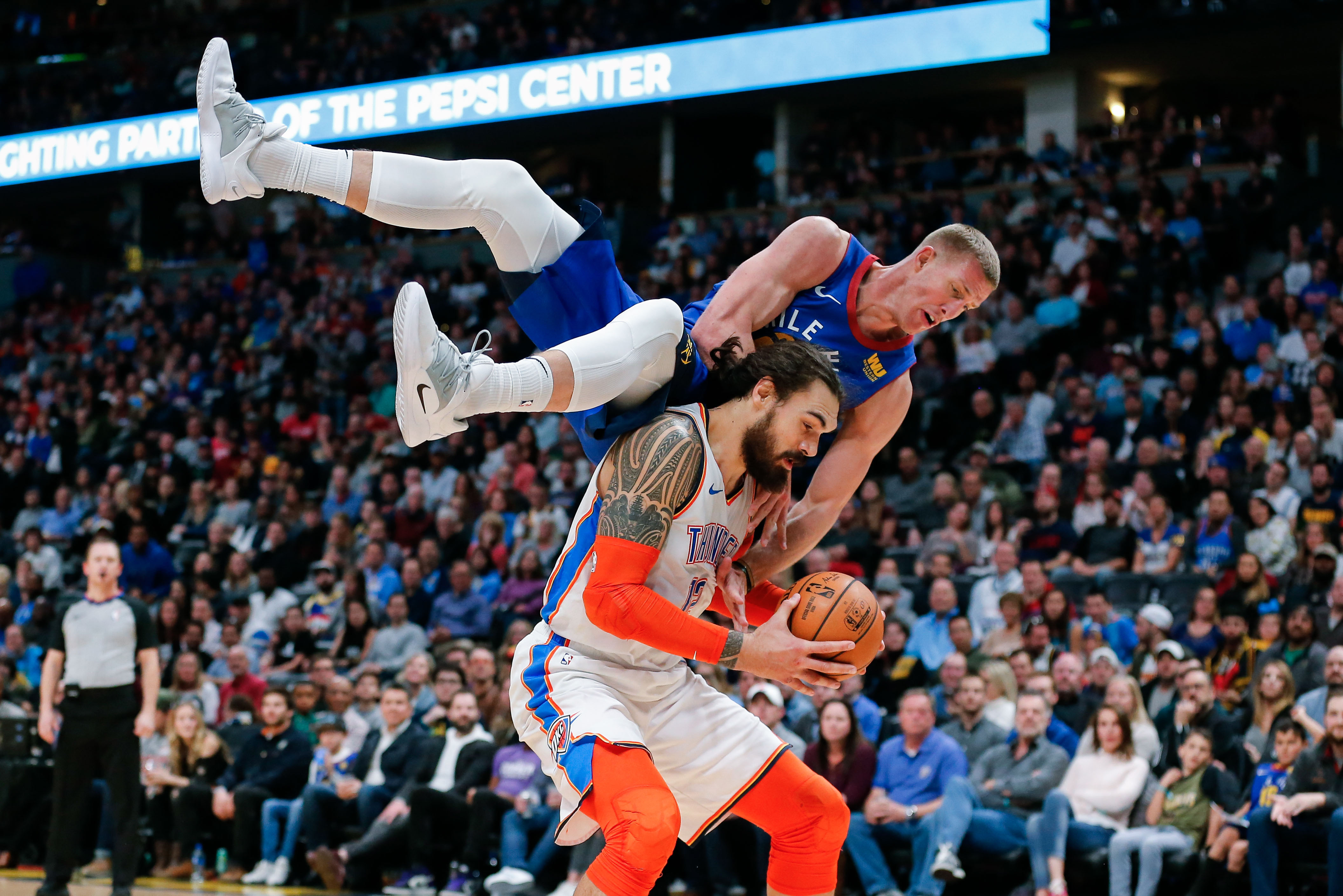 Dec 14, 2018; Denver, CO, USA; Denver Nuggets forward Mason Plumlee (24) falls over the back of Oklahoma City Thunder center Steven Adams (12) in the fourth quarter at the Pepsi Center. Mandatory Credit: Isaiah J. Downing-USA TODAY Sports